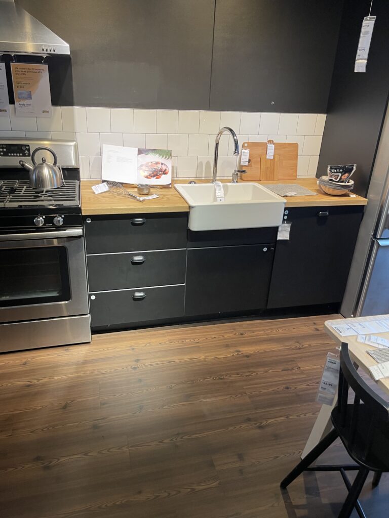 Ikea Kitchen Showroom - black cabinets, butcher block counters, and a farmhouse sink 