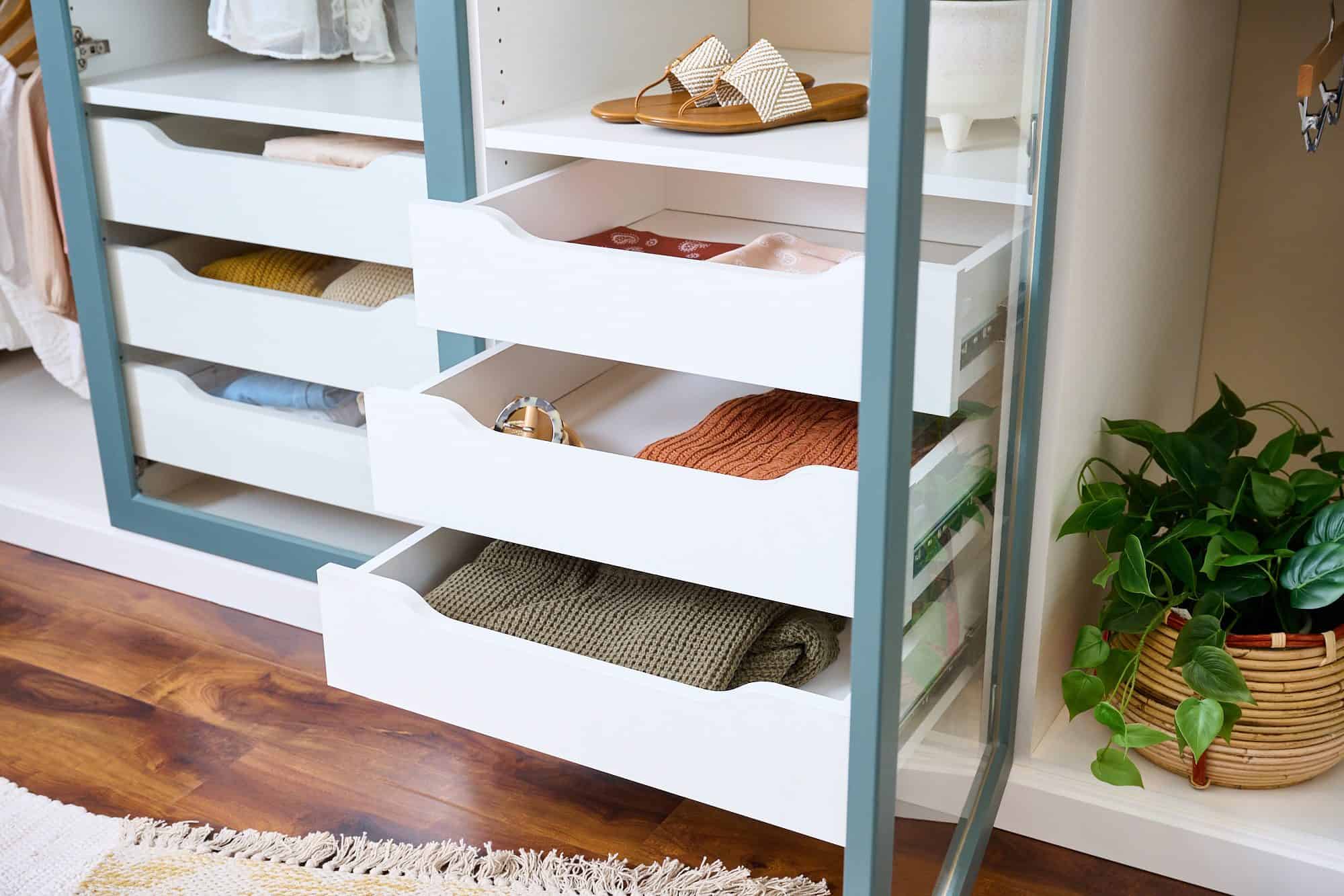 Closet with organized drawers containing clothing and accessories, modern storage solution for homes.